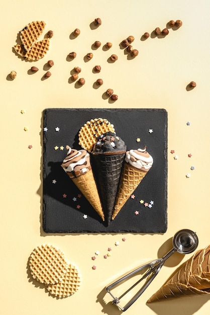 Drie roomijskegels met chocoladeroomijskegels op een gele achtergrond.