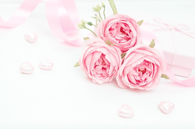 Drie roze rozen met lint en cadeau doos op de witte tafel Valentijnsdag concept