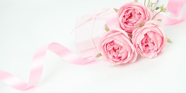 Drie roze rozen met lint en geschenkdoos op de witte tafel Valentijnsdag concept