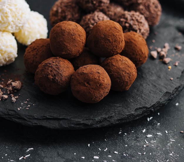 Drie soorten chocoladeballen op stenen bord