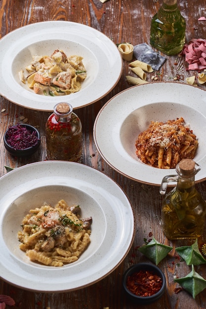 Drie soorten Italiaanse pasta op een houten tafel