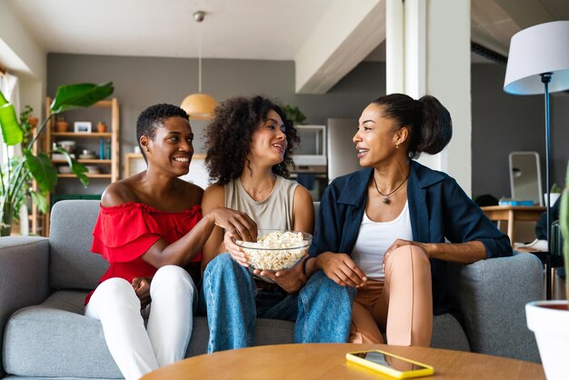 Drie Spaanse en zwarte vrouwen van gemengd ras die thuis een band hebben