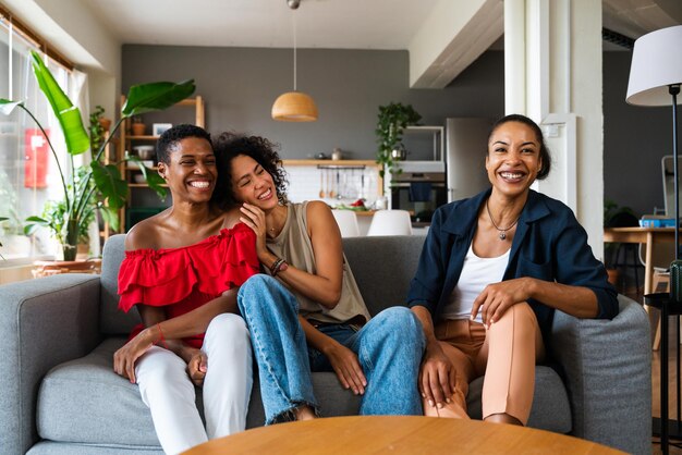 Drie Spaanse en zwarte vrouwen van gemengd ras die thuis een band hebben