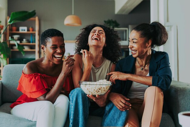 Drie Spaanse en zwarte vrouwen van gemengd ras die thuis een band hebben