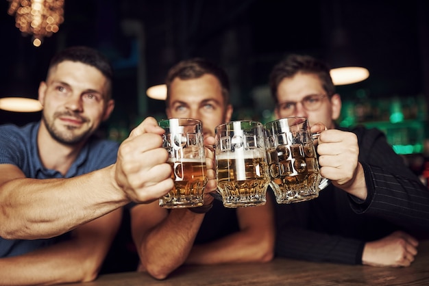 Drie sportfans in een bar voetbal kijken