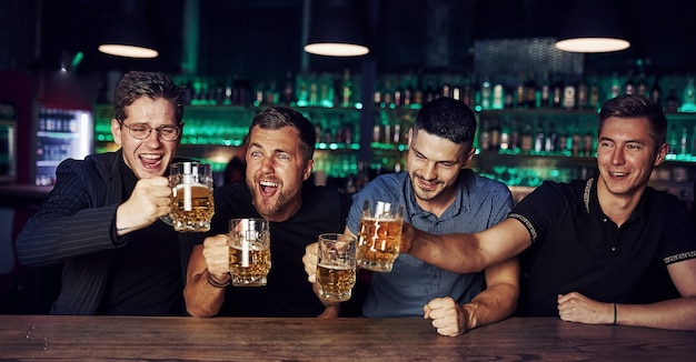 Drie sportfans in een bar voetbal kijken