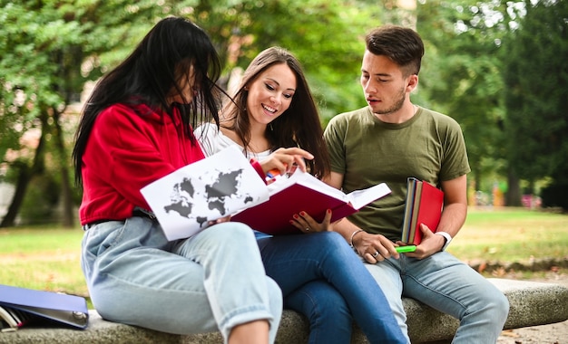 Drie studenten studeren samen zittend op een bankje buiten