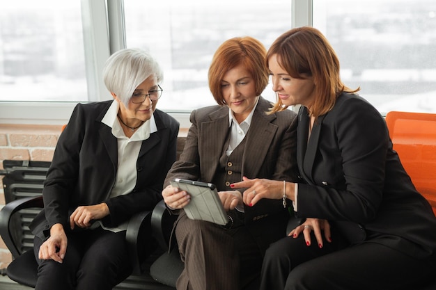 Drie succesvolle vrouwen aan het werk met de tablet