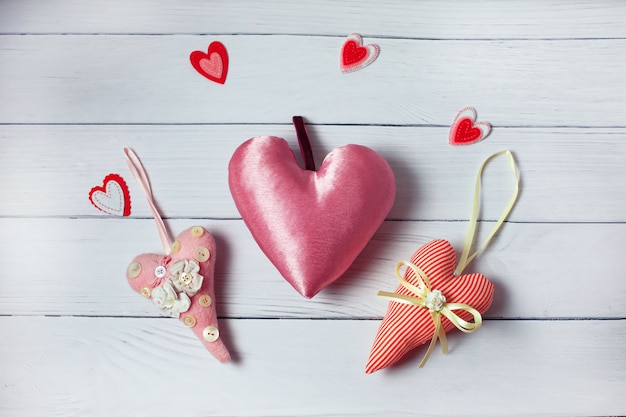 Drie textiel roze harten op houten achtergrond. vintage stijl Valentijnsdag decoratie