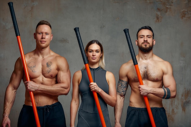 Drie vechtsportmeesters karate taekwondo oefenen Concrete grijze achtergrond Sportbanner