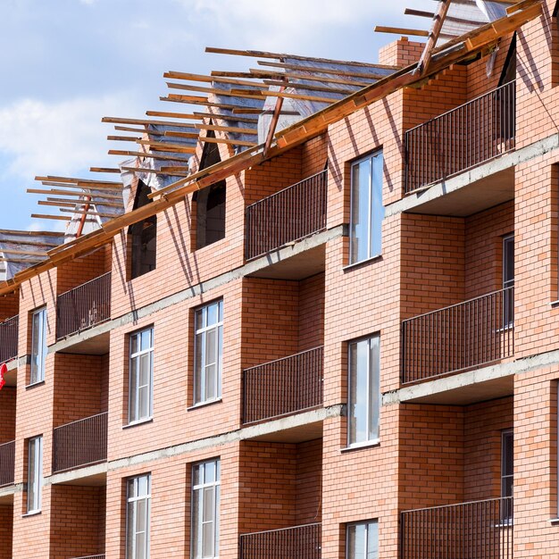 Foto drie verdiepingen tellend stenen appartementengebouw in aanbouw