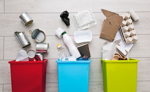 Drie verschillende containers voor het sorteren van afval. Voor plastic, papier, metaal