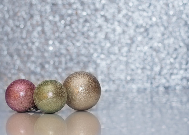 Drie verschillende gekleurde kerstbal op de bokeh.