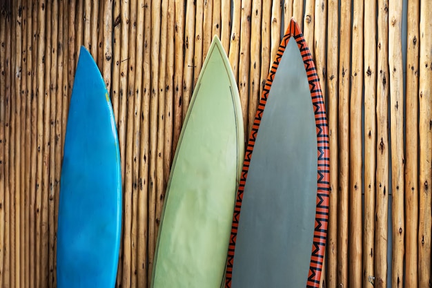 Drie versleten surfplanken tegen de muur gemaakt van bamboe