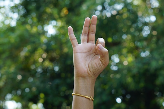 drie vinger menselijke hand groene bokeh achtergrond