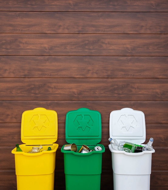 Drie volle vuilnisbakken voor het sorteren van afval in de achtertuin