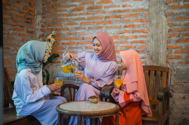 Drie vrienden genieten van verfrissende dranken in een gezellig café vol glimlach en vreugde