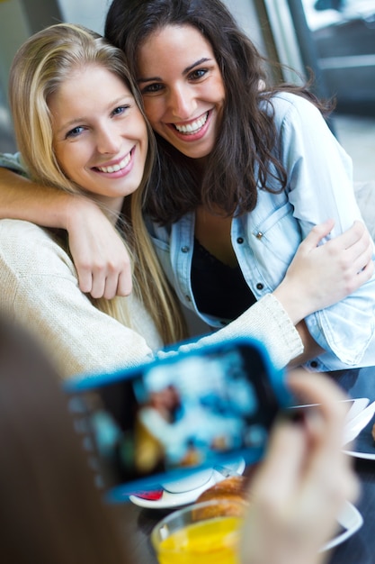 drie vrienden nemen foto&#39;s met een smartphone