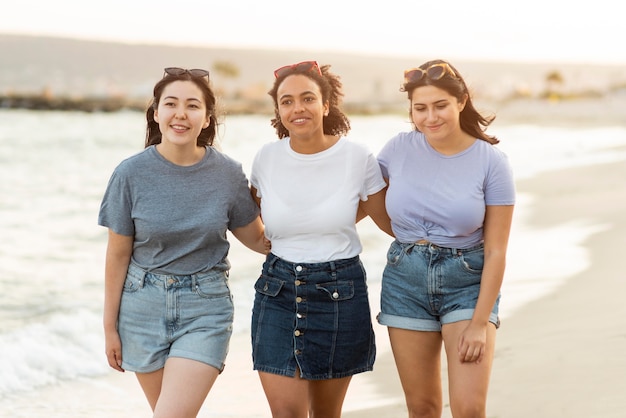 Drie vriendinnen die op het strand lopen