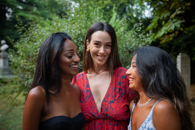 Drie vriendinnen met verschillende etnische achtergronden lachen samen in een openbaar park