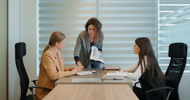 Drie vrouwen die aan een financieel zakelijk doel werken, getoond op papier in het kantoor
