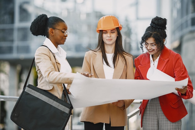 Drie vrouwen die als architecten werken aan een constructie en een beslissing nemen over de plattegrond van een gebouw