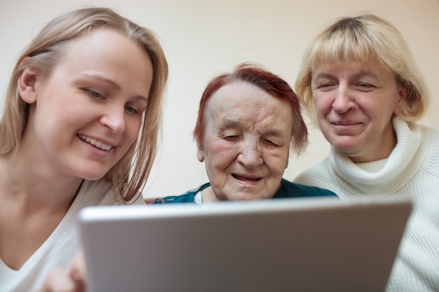 Foto drie vrouwen die een slimme tablet gebruiken