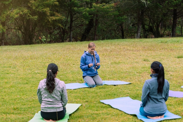 Drie vrouwen in een bos die meditatietechnieken beoefenen. Welzijn.