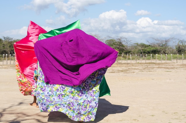 Drie vrouwen met kleurrijke capes dansen typische wayuu-dans inheemse cultuur van la guajira colombia