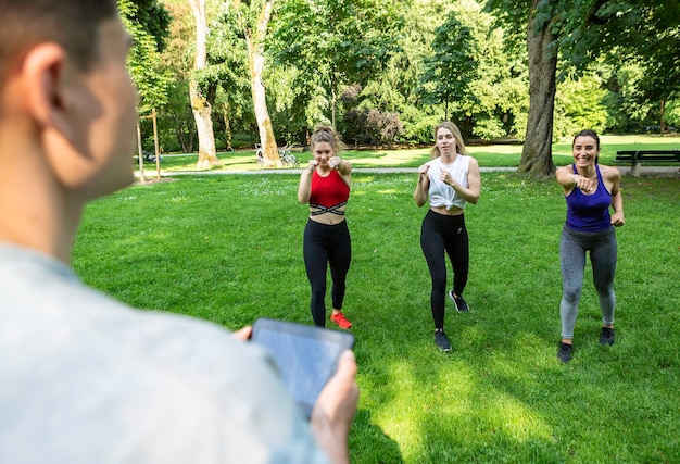 Foto drie vrouwen workout met hun mannelijke crossfit trainer in een park