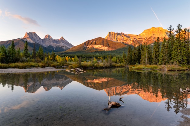 Foto drie zustersberg met de herfst bosbezinning over vijver bij het nationale park van banff