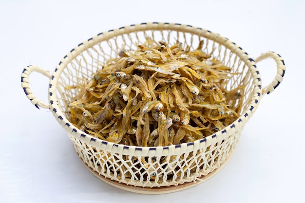 Dried anchovy in bamboo basket on white