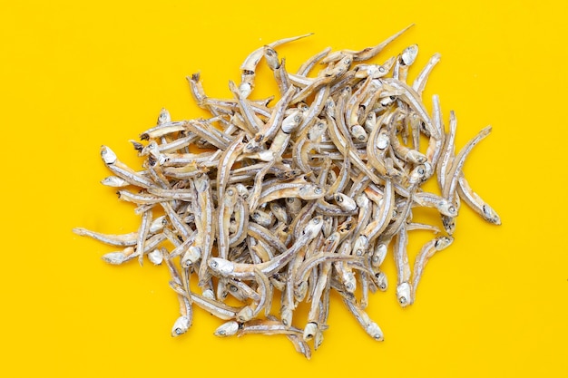 Dried anchovy on yellow background.