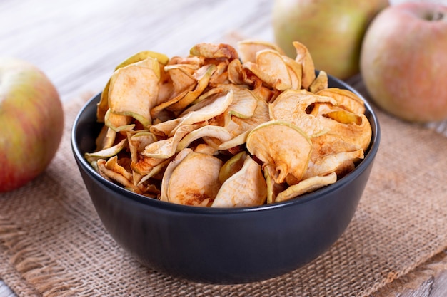 Dried apples in a bowl on wooden table