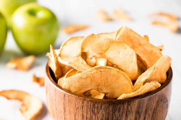 Dried apples in a wooden bowl Ripe green apples on the table