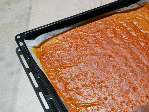 Dried apricot pulp in a tray making pulp on oiled paper apricot pulp