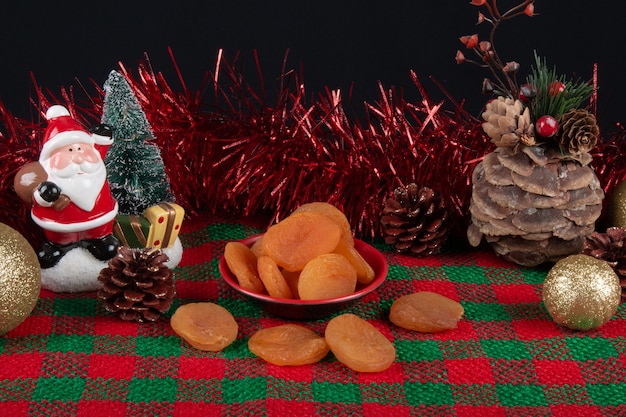 Dried apricots in a bowl on a Christmas background