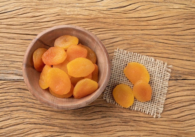 Dried apricots on a bowl over wooden table