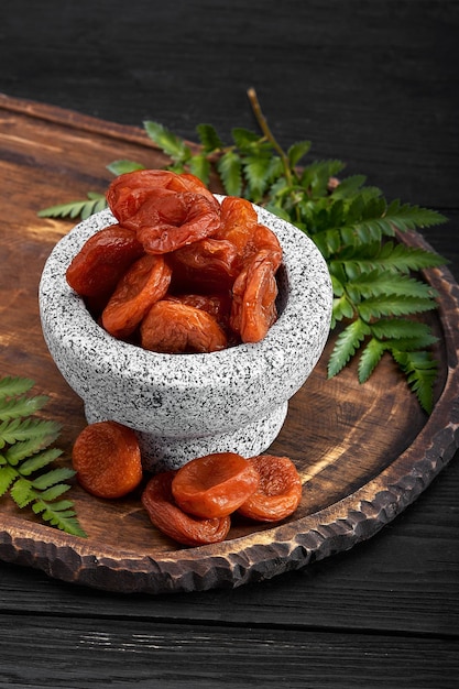 Dried apricots on a dark wood background tinting selective focus