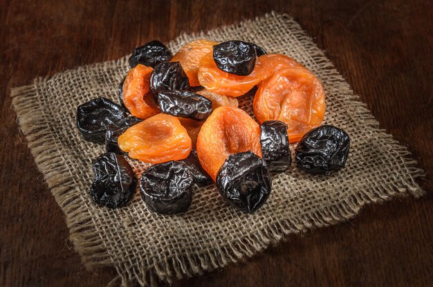 dried apricots and other dried fruits on a dark wooden background