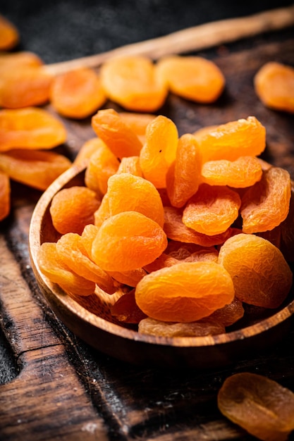 Dried apricots in a plate on a cutting board