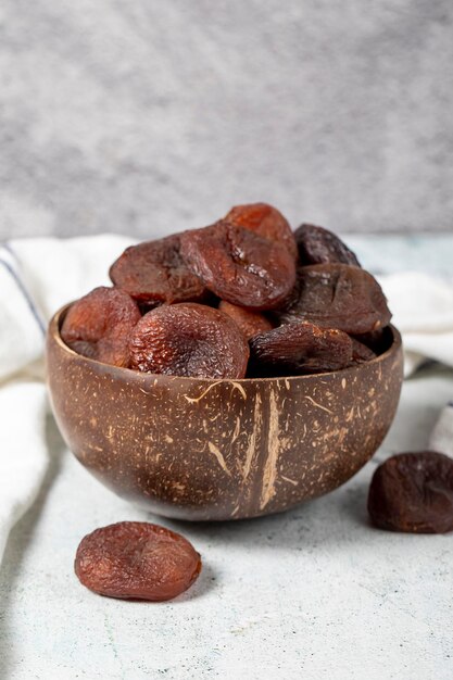 Photo dried apricots on stone background dark dried apricots in a glass bowl diet foods close up