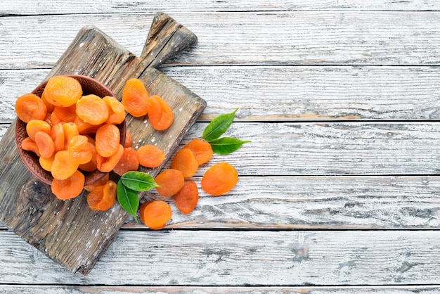 Dried apricots on a white wooden background Dried fruit Top view Free space for your text