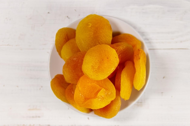 Dried apricots on white wooden table. Top view