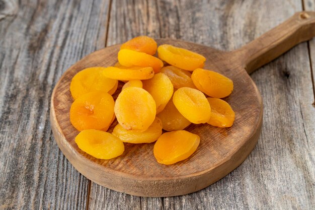 Dried apricots on wood floor Organic and fresh nuts close up