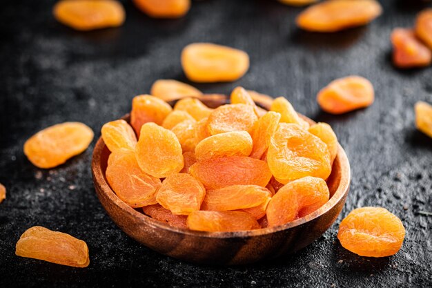 Dried apricots in a wooden plate on the table