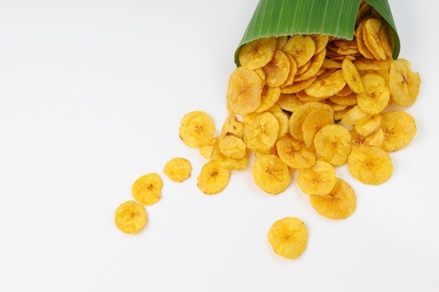 Dried banana chips or banana wafers spilled out from the banana leaf coned