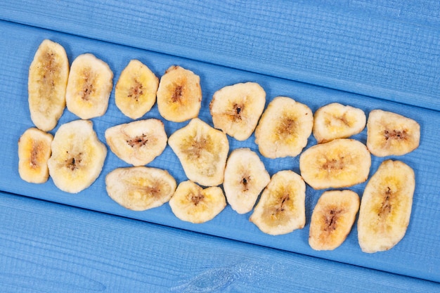 Dried banana chips for snack or dessert on blue boards