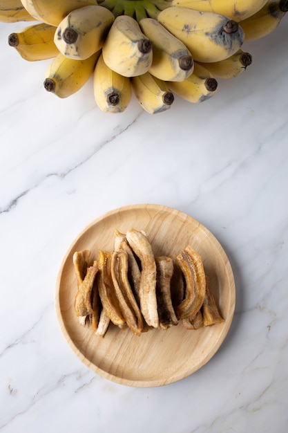 Photo dried banana on marble with real banana