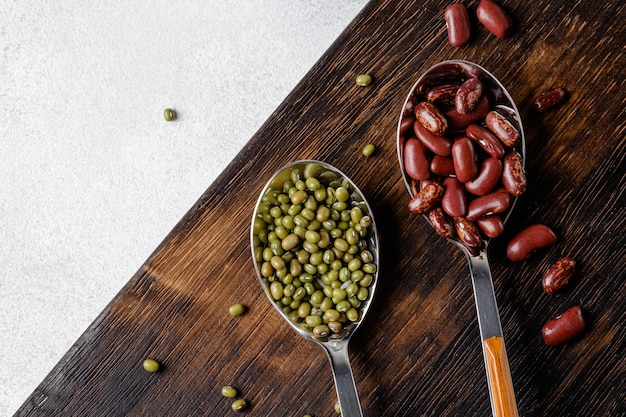 Dried beans in wooden spoons on the table, close up